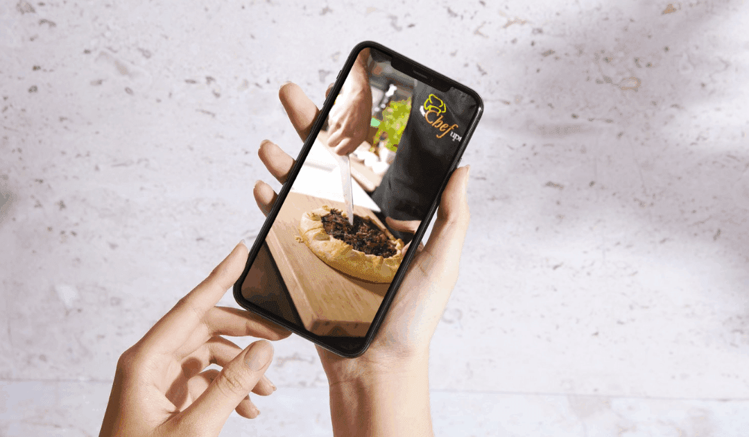 Person holding a phone showing a wild rice and mushroom galette being sliced, made with Monark Wild Rice.